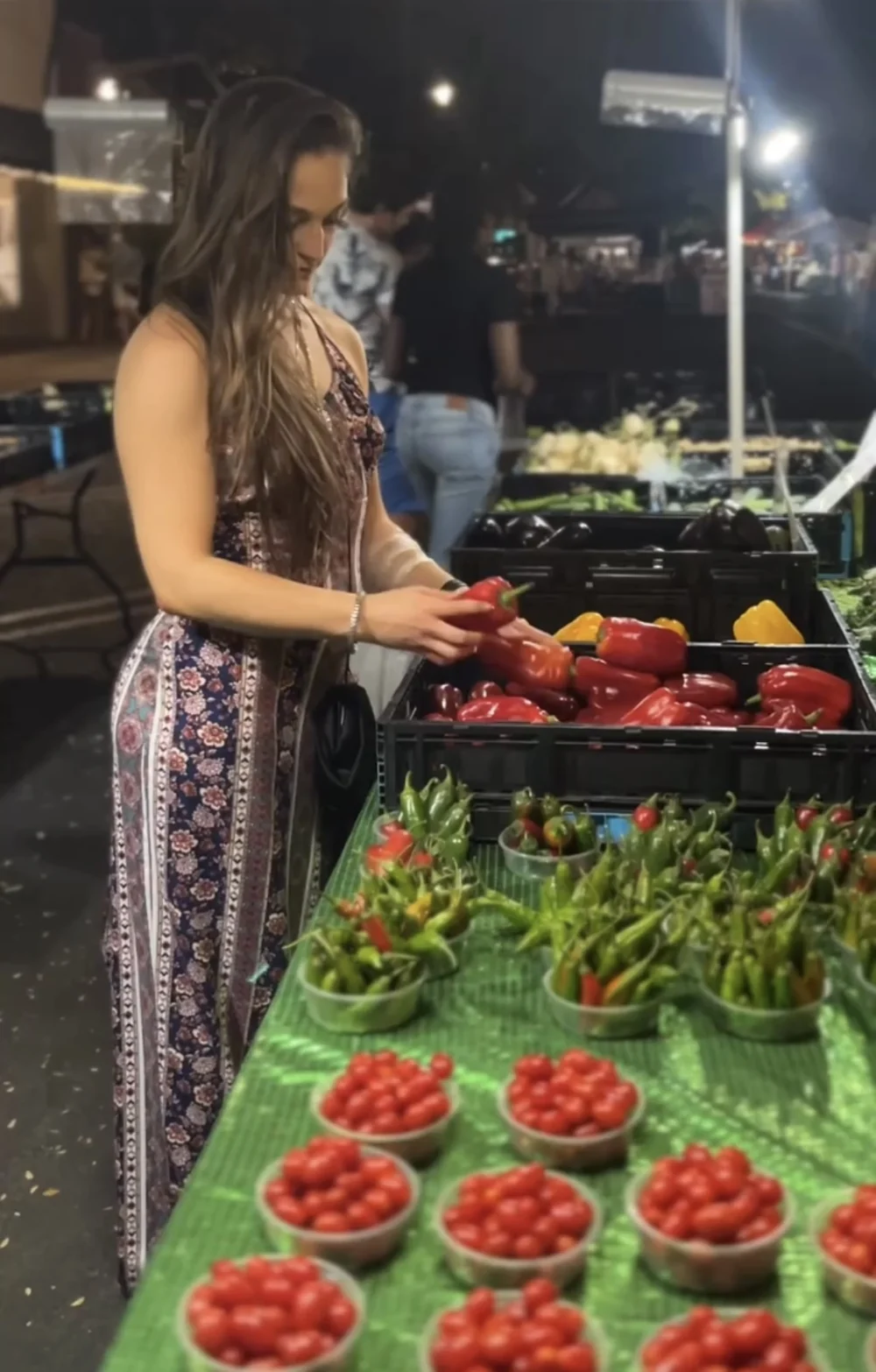 Hannah Howerton selecting fresh peppers at a farmers market